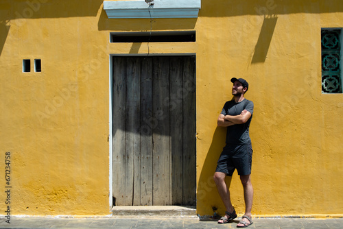 Traveler in front of real Hoi An yellow wall. Concept of tourism, travel and holidays.