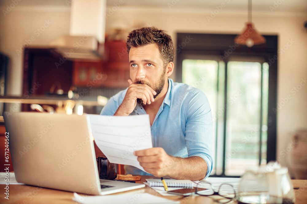 Man deeply contemplating a document in his home office
