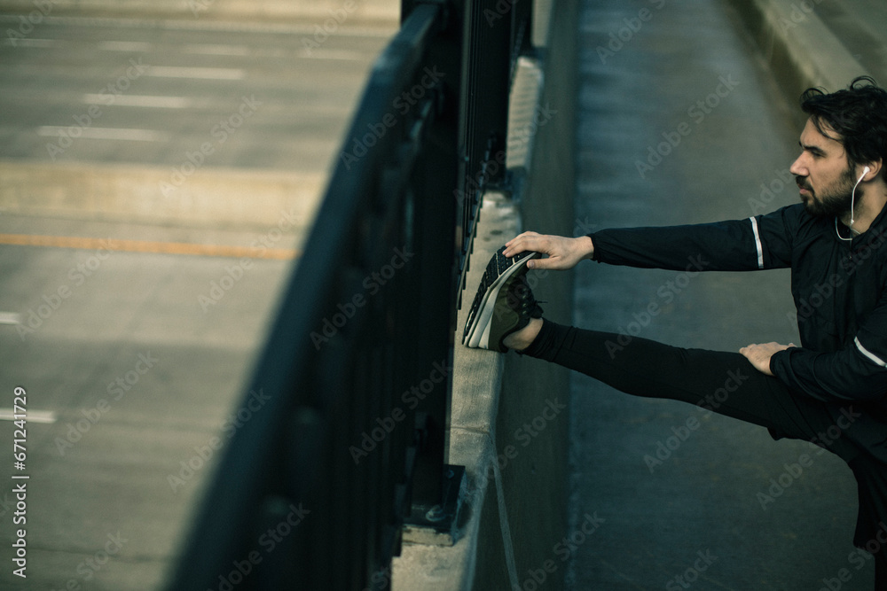 Man stretching by the railing before a run