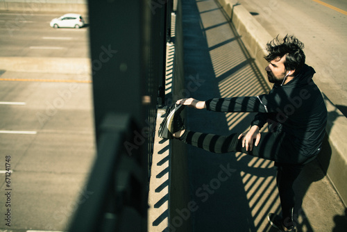 Man stretching by the railing before a run