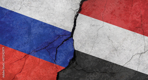 Russia and Yemen flags, concrete wall texture with cracks, grunge background, military conflict concept