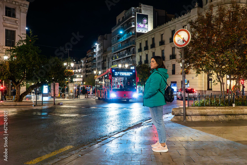 Girl waiting for a bus in the Granada night photo