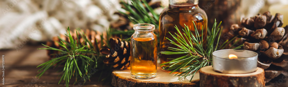 Aromatic home apartment diffuser with the fresh pine fragrance. Spruce, fir tree branches, wooden background. Essential oils, candle as table decor. Cozy atmosphere, Christmas spirit. Banner Aromatic home apartment diffuser with the fresh pine fragrance. Spruce, fir tree branches, wooden background. Essential oils, candle as table decor. Cozy atmosphere, Christmas spirit. Banner