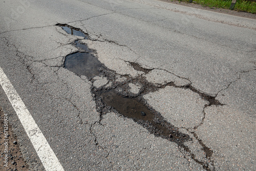 Potholes on bad asphalt road. Closeup photo