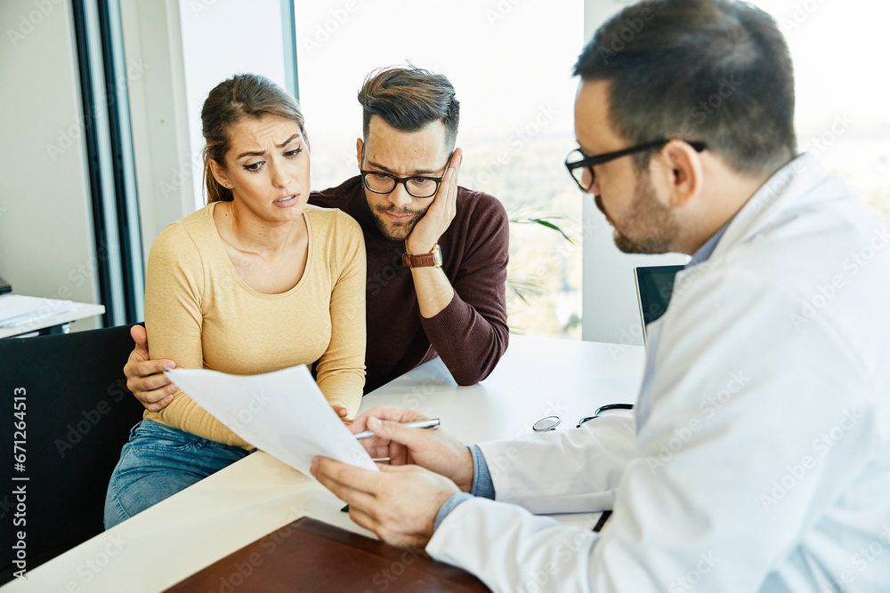 Obraz premium doctor woman man patient hospital care clinic couple young health female medical medicine discussion husband talking wife office family consultation happy appointment treatment