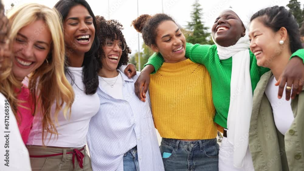 Multi ethnic group of young women hugging outside - Happy girlsfriends having fun laughing out loud on city street - Female community concept with cheerful girls standing together