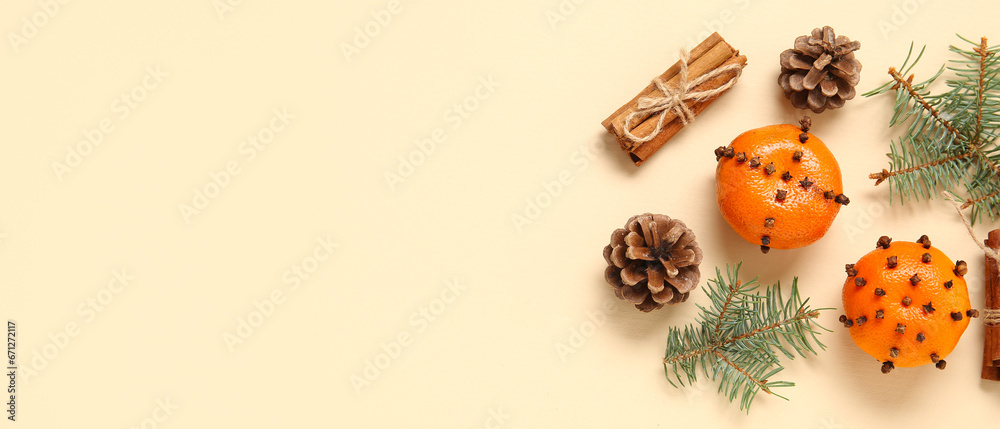 Pomander balls, Christmas tree branches, cones and cinnamon on beige background with space for text, top view
