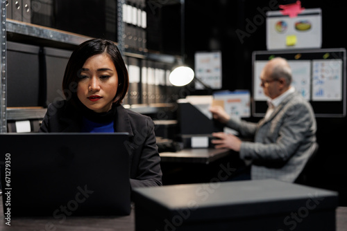 Fotografie Professional business workers checking administrative analytical data in bureaucratic office filled with invoice folders