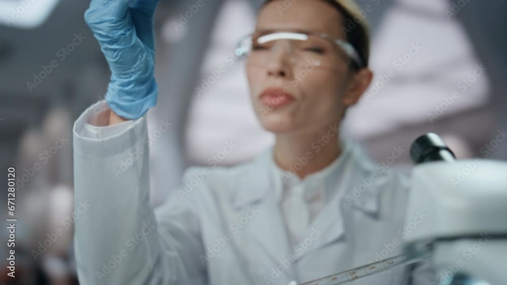 Lab worker filling test tube with experimental drug making research close up.