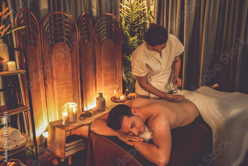 Masseur hands pouring aroma oil on man back. Masseuse prepare oil massage procedure for customer at spa salon in luxury resort. Aroma oil body massage therapy concept. Quiescent