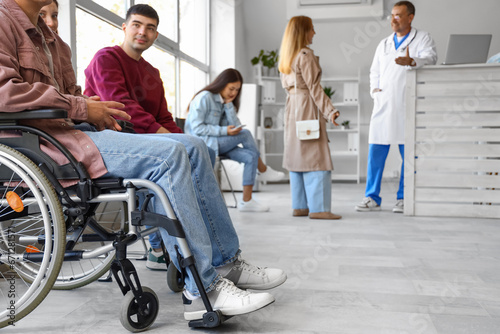 Young man in wheelchair waiting for his turn at hospital