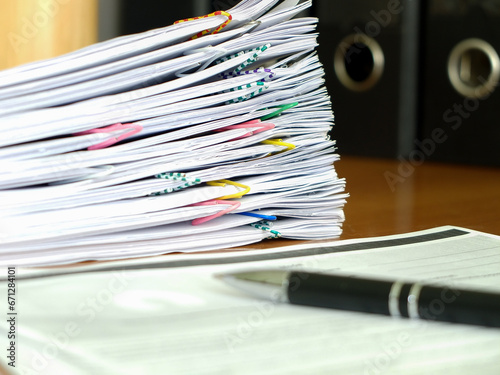 A stack of papers and a pen on the desk