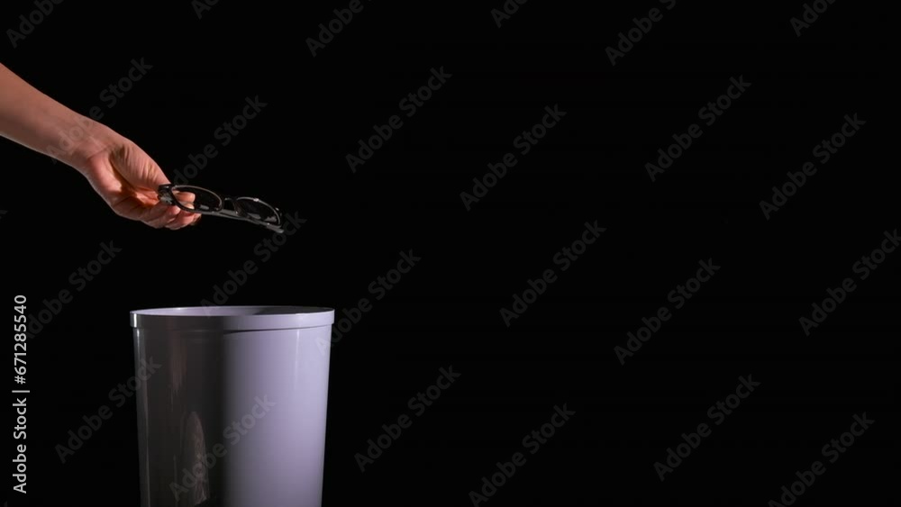Throw glasses into trash bin. A person throw glasses into the plastic