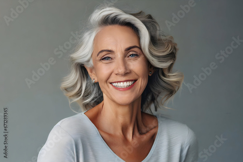 Beautiful gorgeous 50s mid age beautiful elderly senior model woman with grey hair laughing and smiling. Mature old lady close up portrait. Healthy face skin care beauty, skincare cosmetics, dental. photo