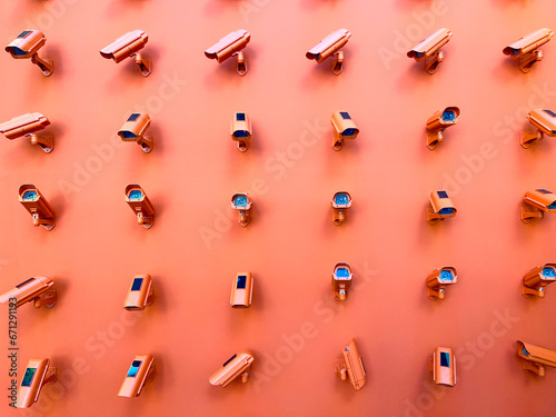 Εκτύπωση καμβά Horizontal photography of a bunch of CCTV cameras pointing in all directions mounted on an orange wall