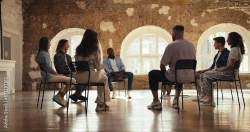 Group therapy meeting for adults in a brick room. Participants in group therapy sit in a circle and communicate