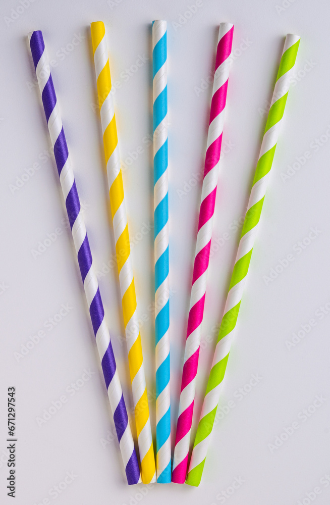 Five stripy coloured paper straws on a white background Five stripy coloured paper straws on a white background