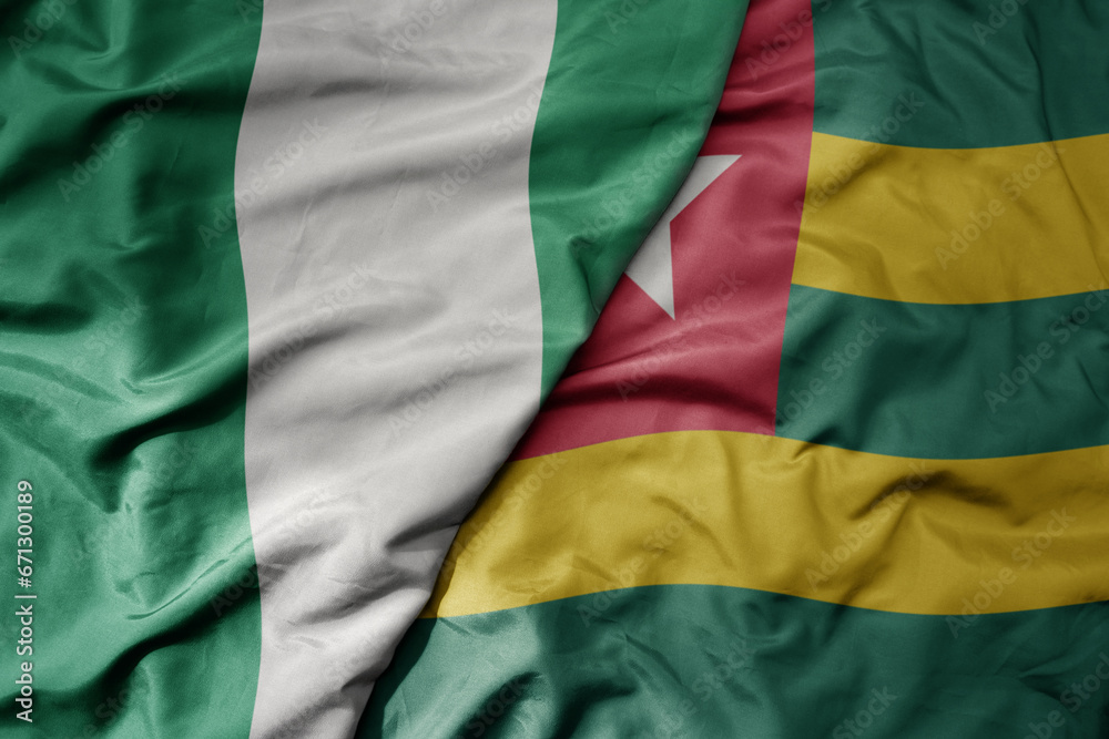 big waving national colorful flag of nigeria and national flag of togo . big waving national colorful flag of nigeria and national flag of togo .