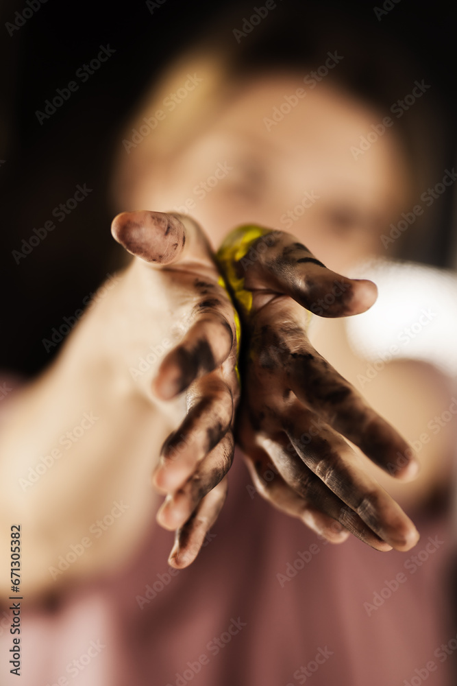 Female artist making an artistic painting with her hands. Girl mixing colors and painting hands.