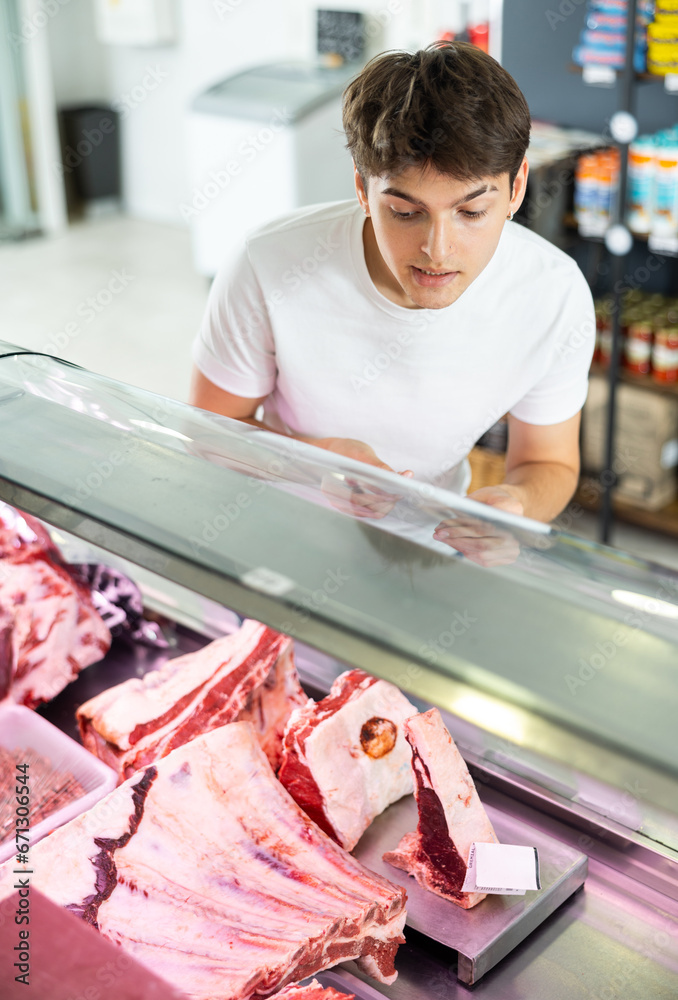 With wide range of fresh cuts on display, shopper makes his choice from assortment.