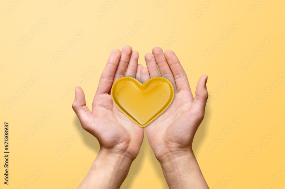 Hands holding a small yellow heart