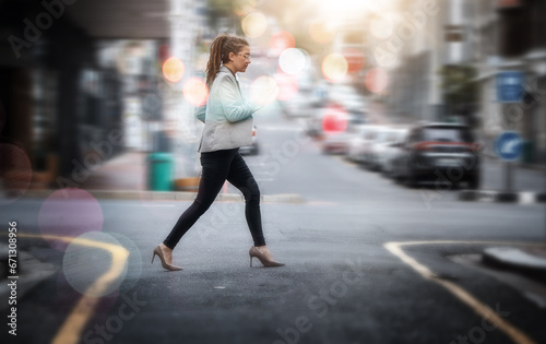 Walking, business and a woman crossing a street in the city while in a rush or late for work. Road, pedestrian and travel with a young female employee on her commute in an urban town for opportunity