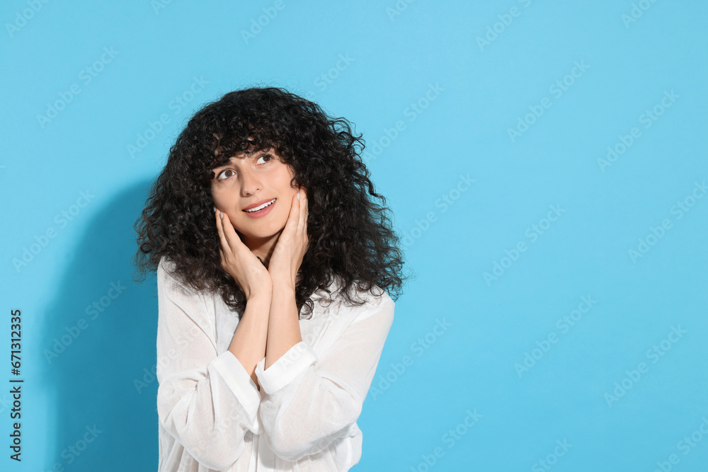 Portrait of beautiful young woman on light blue background, space for text Portrait of beautiful young woman on light blue background, space for text
