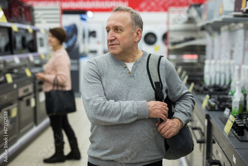 Portrait of a confident European man of mature age, who came to the electronics and household appliances store for a ..purchase, in the gas stoves department