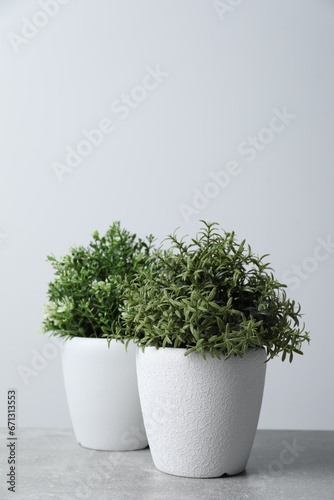 Artificial potted herbs on light grey table