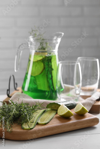 Fresh homemade refreshing tarragon drink and ingredients on white wooden table
