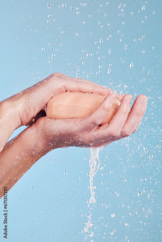 Water, soap and a person washing hands in studio on a blue background for hygiene or hydration. Cleaning, wellness and skincare with an adult in the bathroom to remove bacteria or germs for health