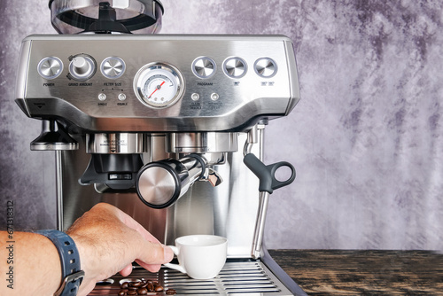 Modern espresso coffee machine. Boristo's hand holds a cup. photo