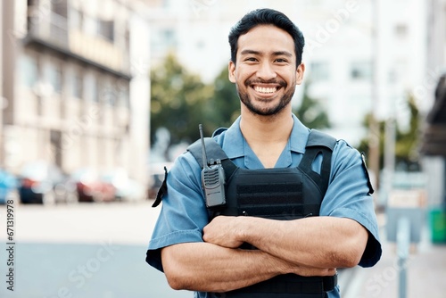Portrait, happy or policeman in city with arms crossed for law enforcement, surveillance or street safety. Confident cop, smile or proud Asian security guard on patrol in town for crime or justice photo
