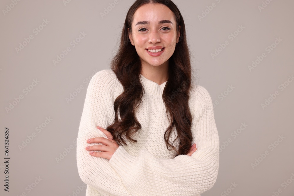 Beautiful young woman in stylish warm sweater on grey background Beautiful young woman in stylish warm sweater on grey background