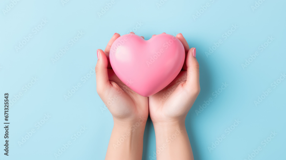hands hold a pink heart on a minimal light blue background hands hold a pink heart on a minimal light blue background