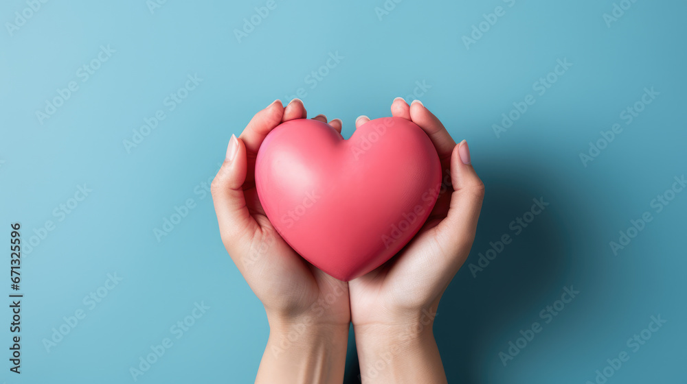 hands hold a pink heart on a minimal light blue background hands hold a pink heart on a minimal light blue background