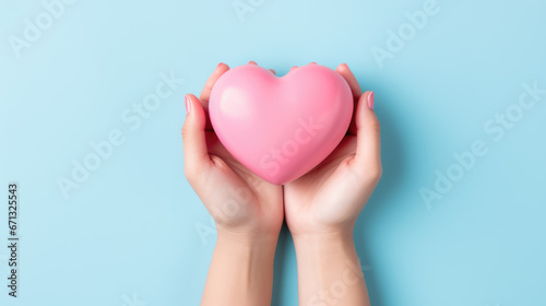 hands hold a pink heart on a minimal light blue background