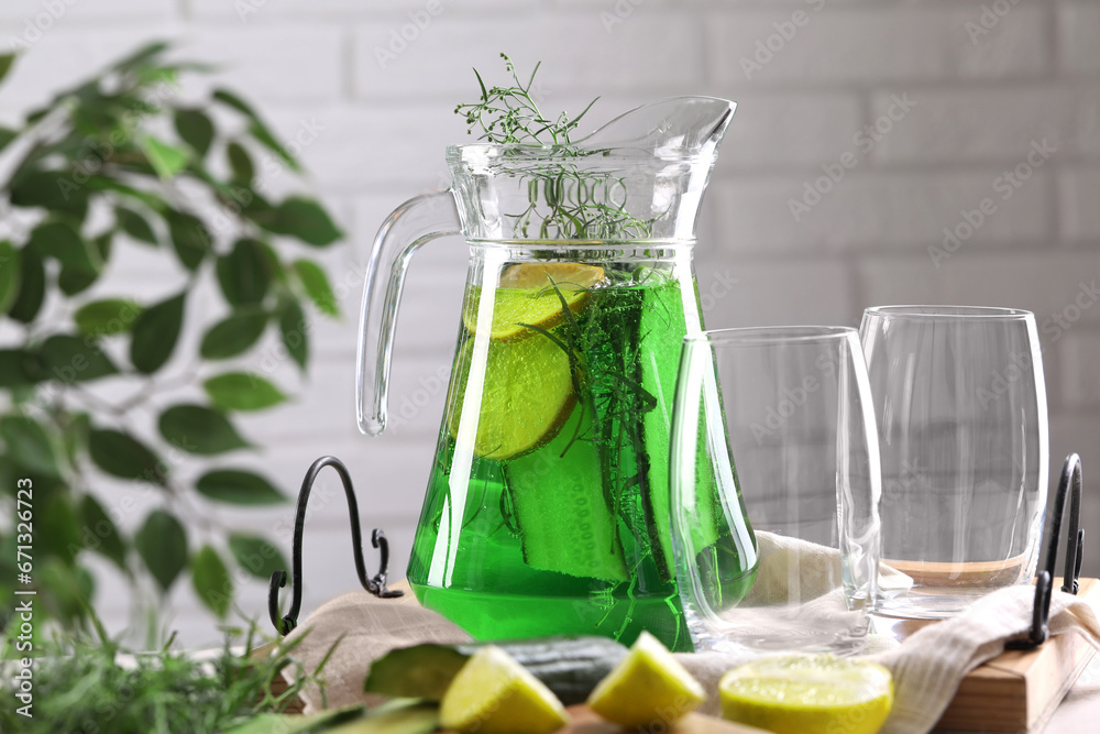 Jug of homemade refreshing tarragon drink and glasses on table Jug of homemade refreshing tarragon drink and glasses on table