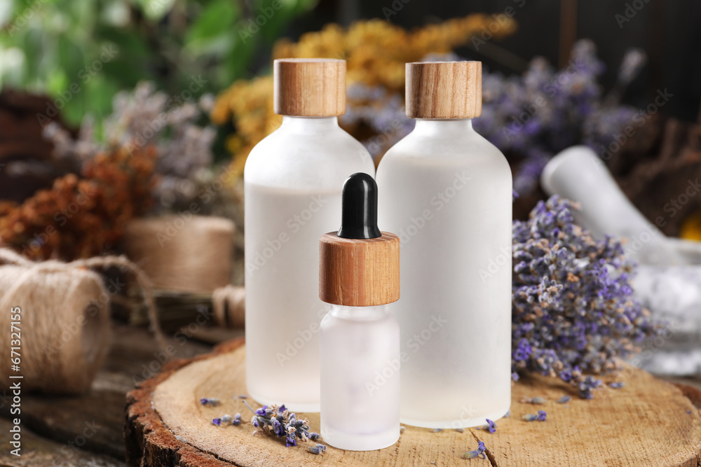 Bottles of essential oils and dry lavender flowers on wooden table, closeup. Medicinal herbs Bottles of essential oils and dry lavender flowers on wooden table, closeup. Medicinal herbs