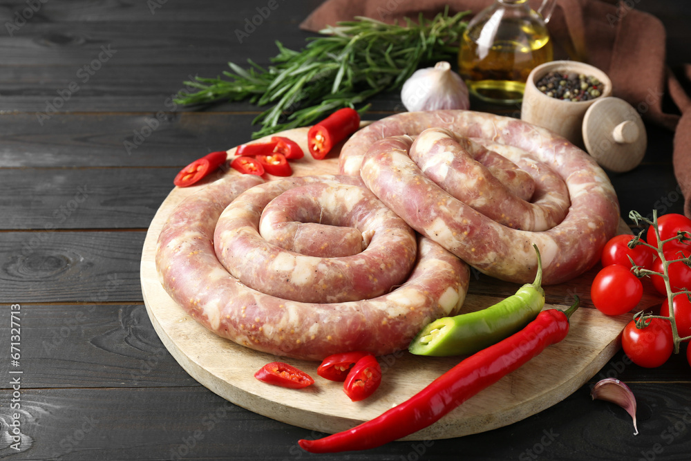 Raw homemade sausages, spices and other products on dark wooden table, closeup Raw homemade sausages, spices and other products on dark wooden table, closeup