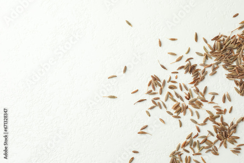 Aromatic caraway (Persian cumin) seeds on white table, top view. Space for text