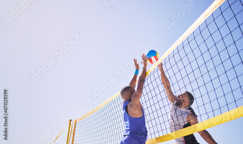 Beach, volleyball and men jumping at net with sports action, fun and summer competition with blue sky. Energy, ocean games and volley challenge with team hitting ball for goal at match in nature. photo