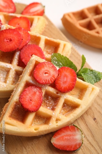 Tasty Belgian waffles with strawberries and mint on table, closeup