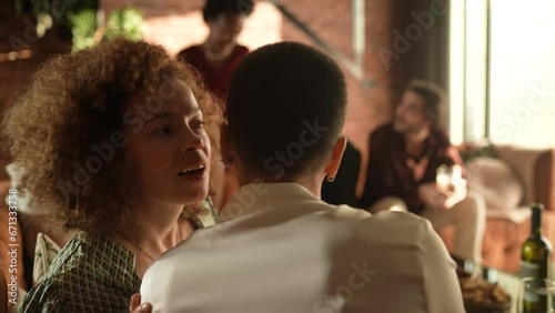 Woman whispering a secret to her friend during a home party