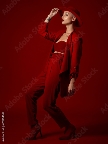 фотографія Art, fashion and a model woman on a red studio background for elegant or trendy style