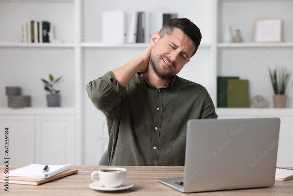 Man suffering from neck pain in office