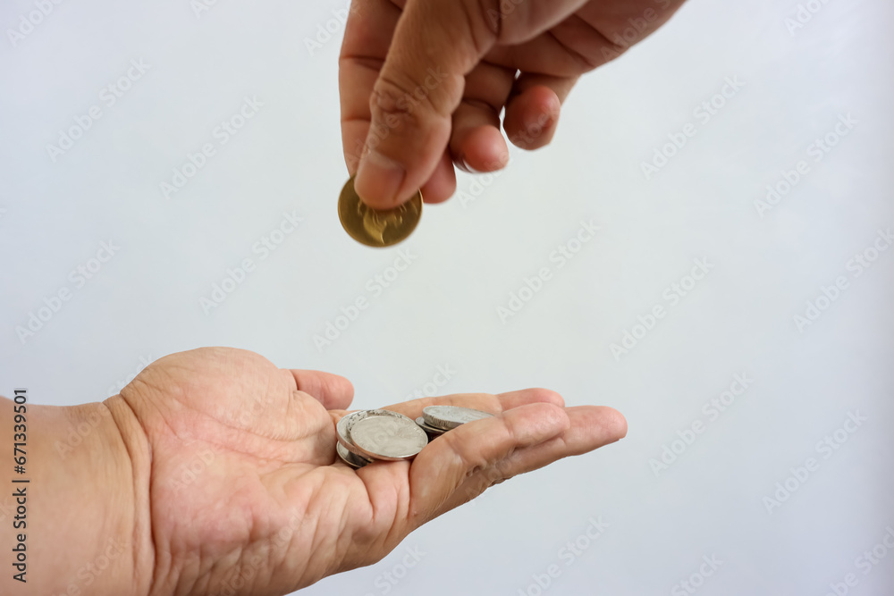 Man hand giving coin to woman hand isolated on white background. Giving, taking, charity or donation concept Man hand giving coin to woman hand isolated on white background. Giving, taking, charity or donation concept