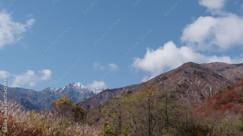 紅葉が終わりかけの山の向こうに見える、雪が積もり始めた五竜岳 紅葉が終わりかけの山の向こうに見える、雪が積もり始めた五竜岳