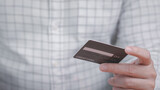 Man holding credit card and looking for information to pay and spend money payment for goods from online shopping via credit card. Finance and banking concepts.