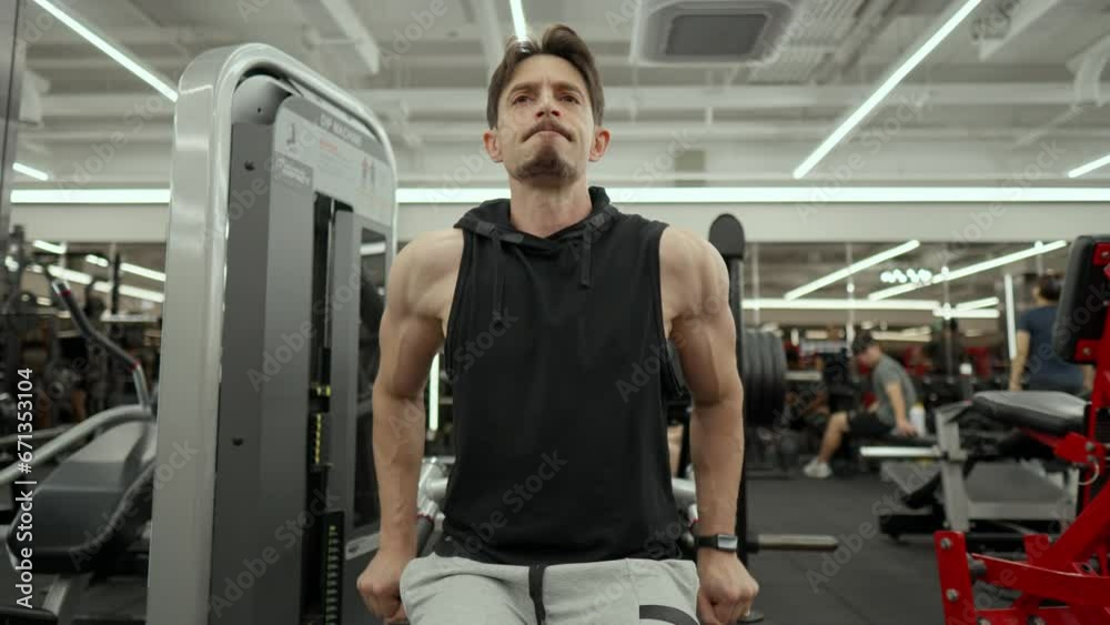 Muscular Senior Man with Beard Train Lower Chest in Dips Machine - low angle Muscular Senior Man with Beard Train Lower Chest in Dips Machine - low angle